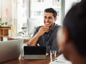 Shot of a handsome young businessman smiling during a meeting with colleagues at work