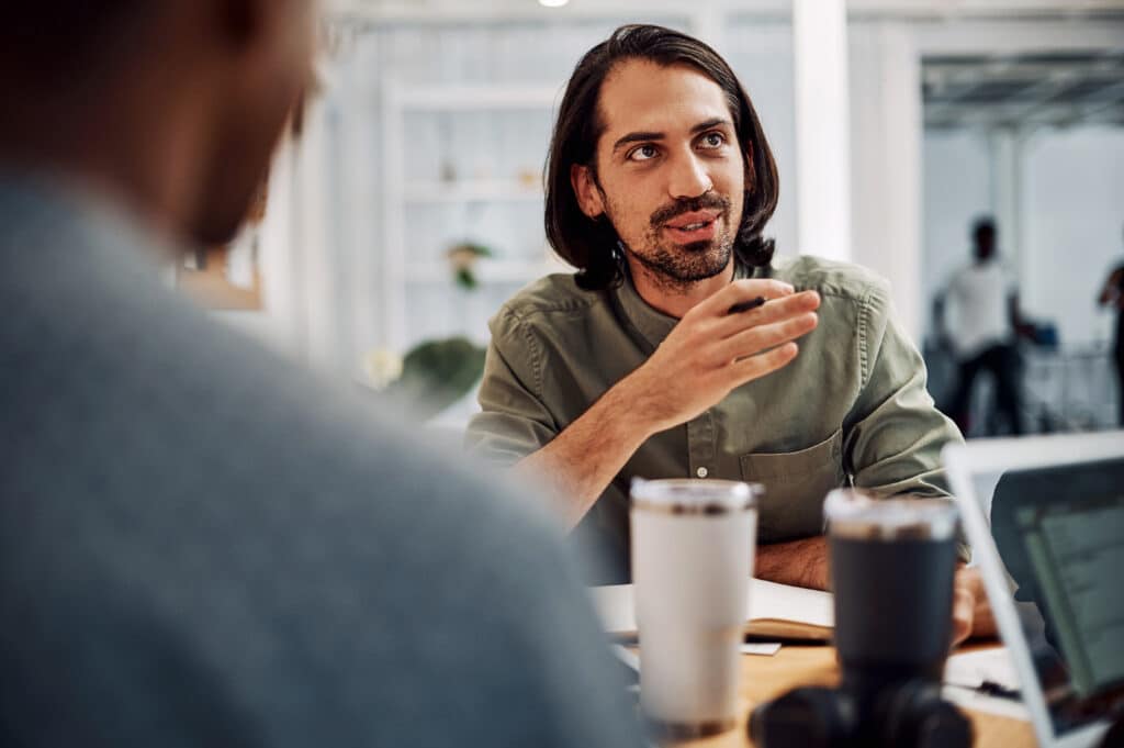 Cropped shot of a handsome young businessman sitting with his male colleagues in the office