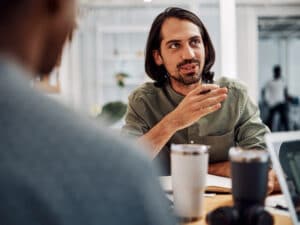 Cropped shot of a handsome young businessman sitting with his male colleagues in the office