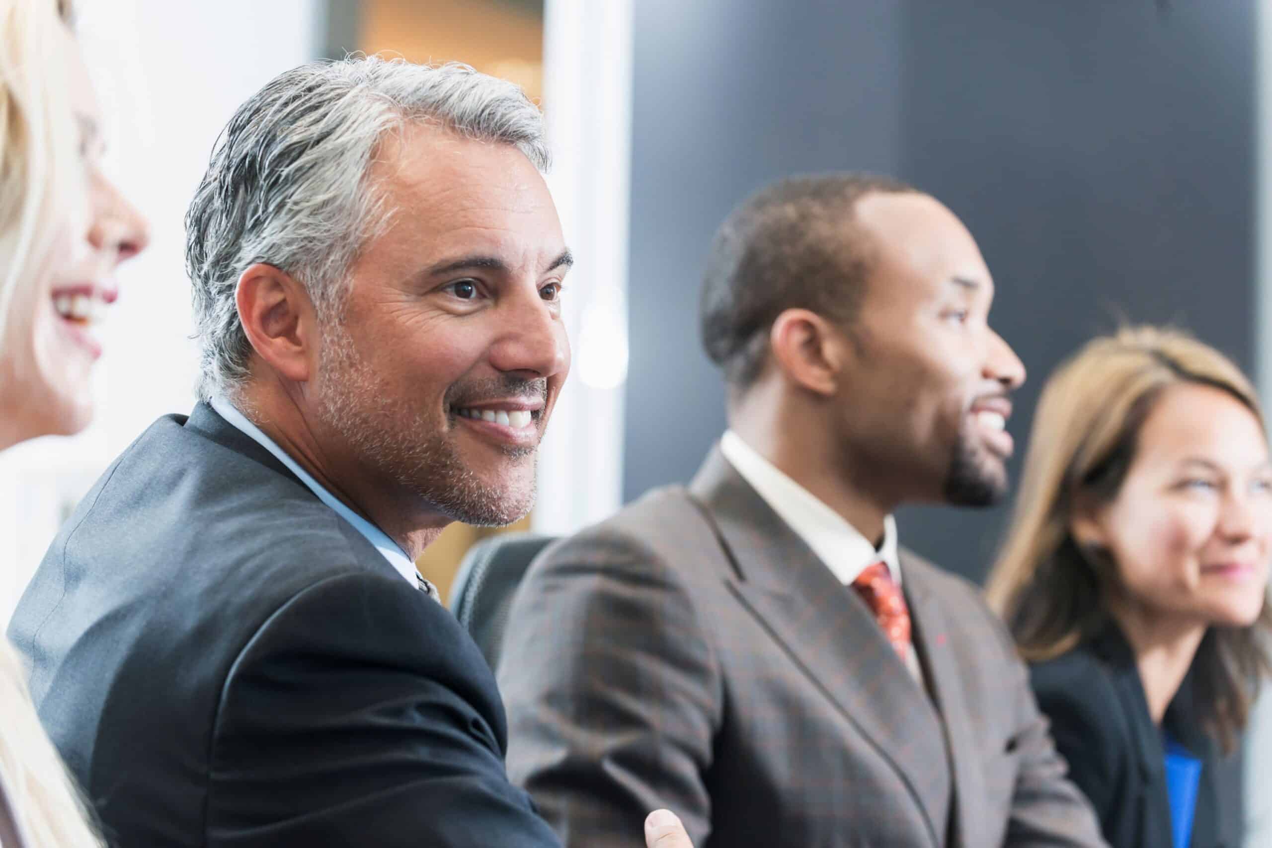 A group of people smiling in a formal setting